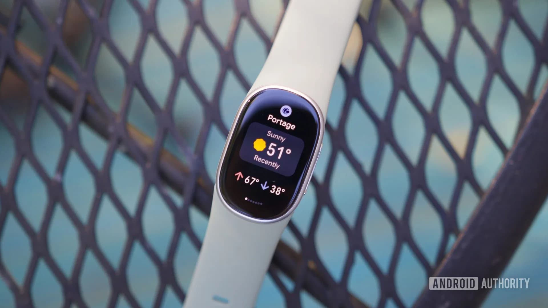 A Fitbit Edge fitness tracker shown alongside a Google Pixel Watch 5, an Oura Ring 5, and a Samsung Galaxy Fit 3 on a flat surface.