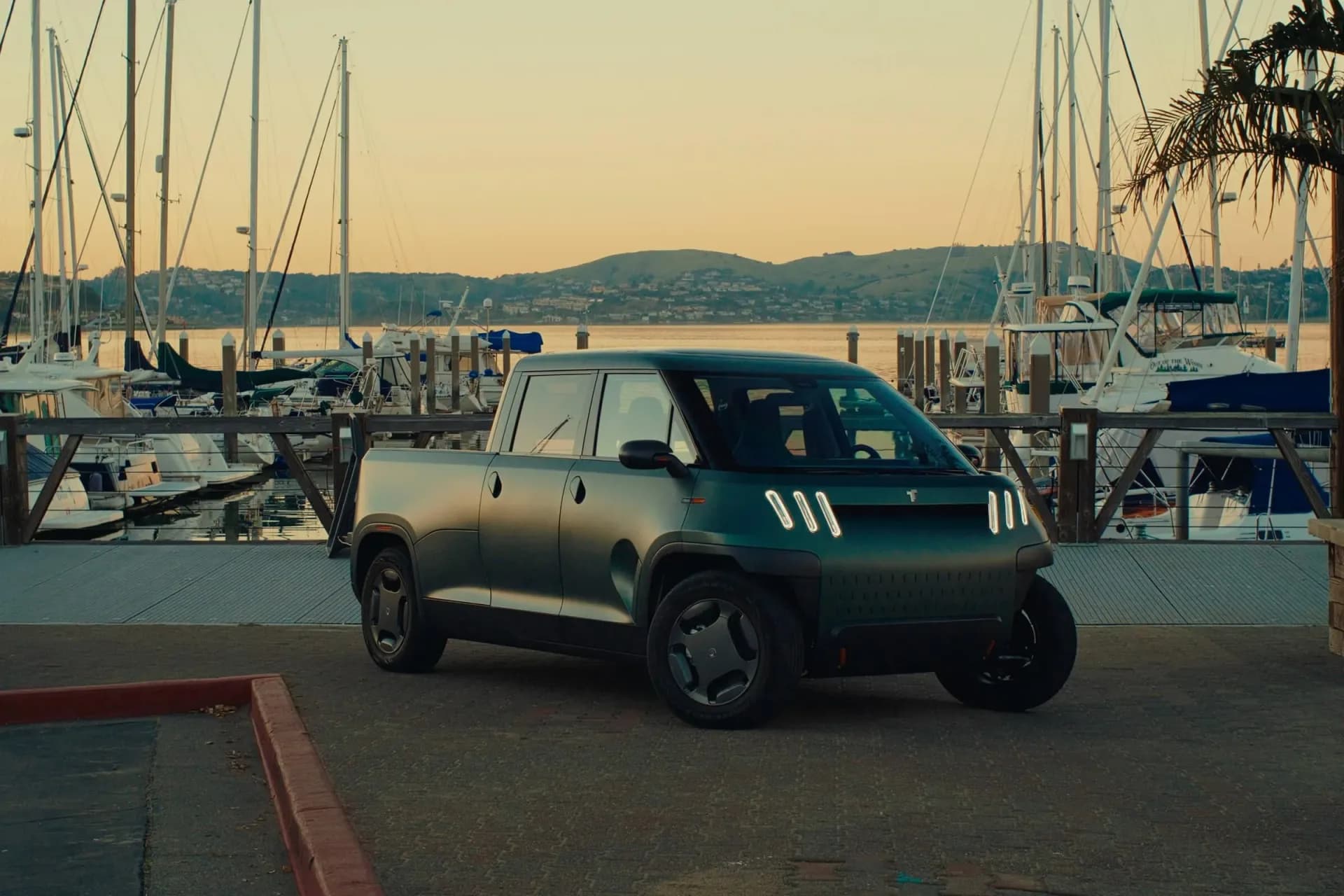 Front three-quarter view of the compact four-door Telo MT1 electric pickup prototype parked on city asphalt.