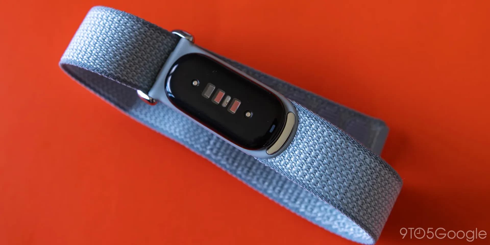 A Fitbit Air fitness tracker displaying health data on its screen