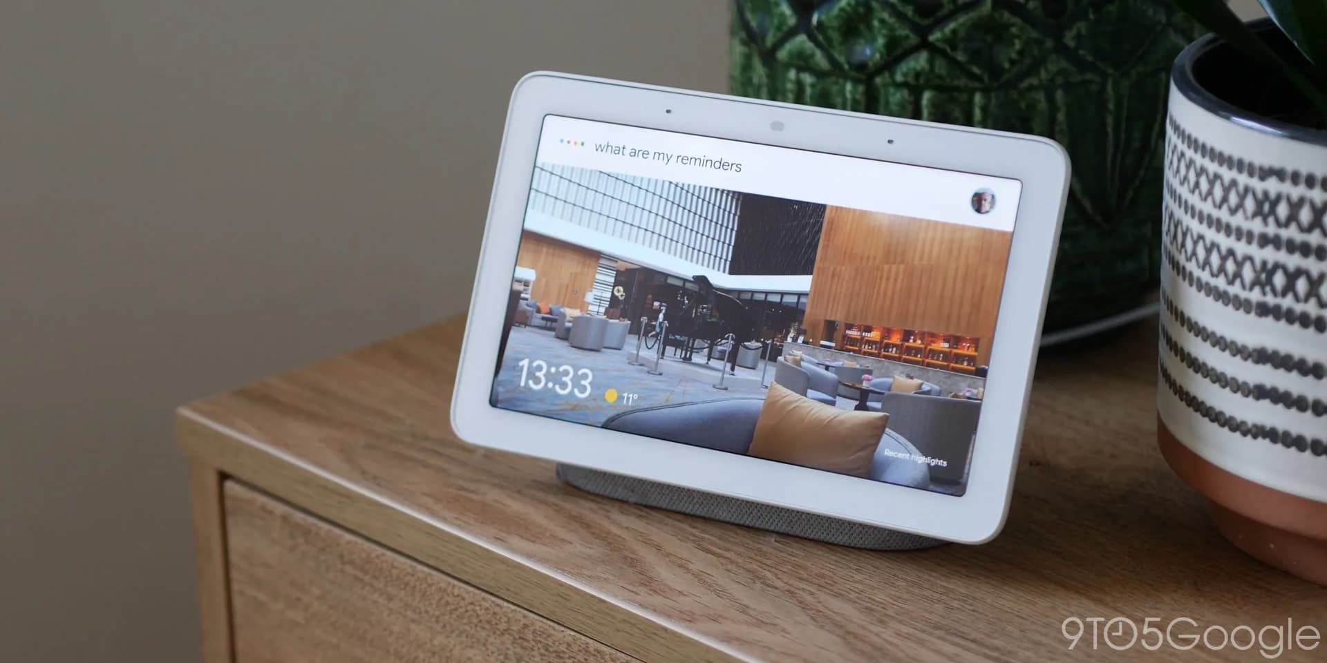 A Google Nest smart speaker sitting on a shelf in a home.