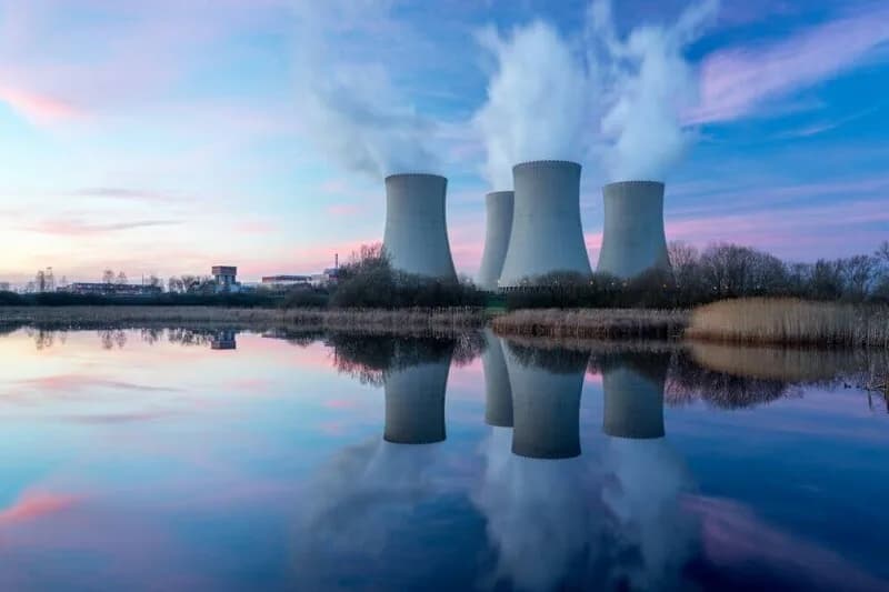 Illustration of a nuclear power plant cooling tower with transmission lines leading to a data center building