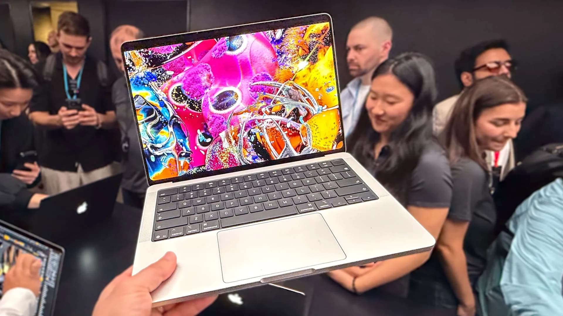 A MacBook Pro with PROLED XDR display shown next to a Lenovo Yoga Pro 9i Aura Edition laptop with tandem OLED screen