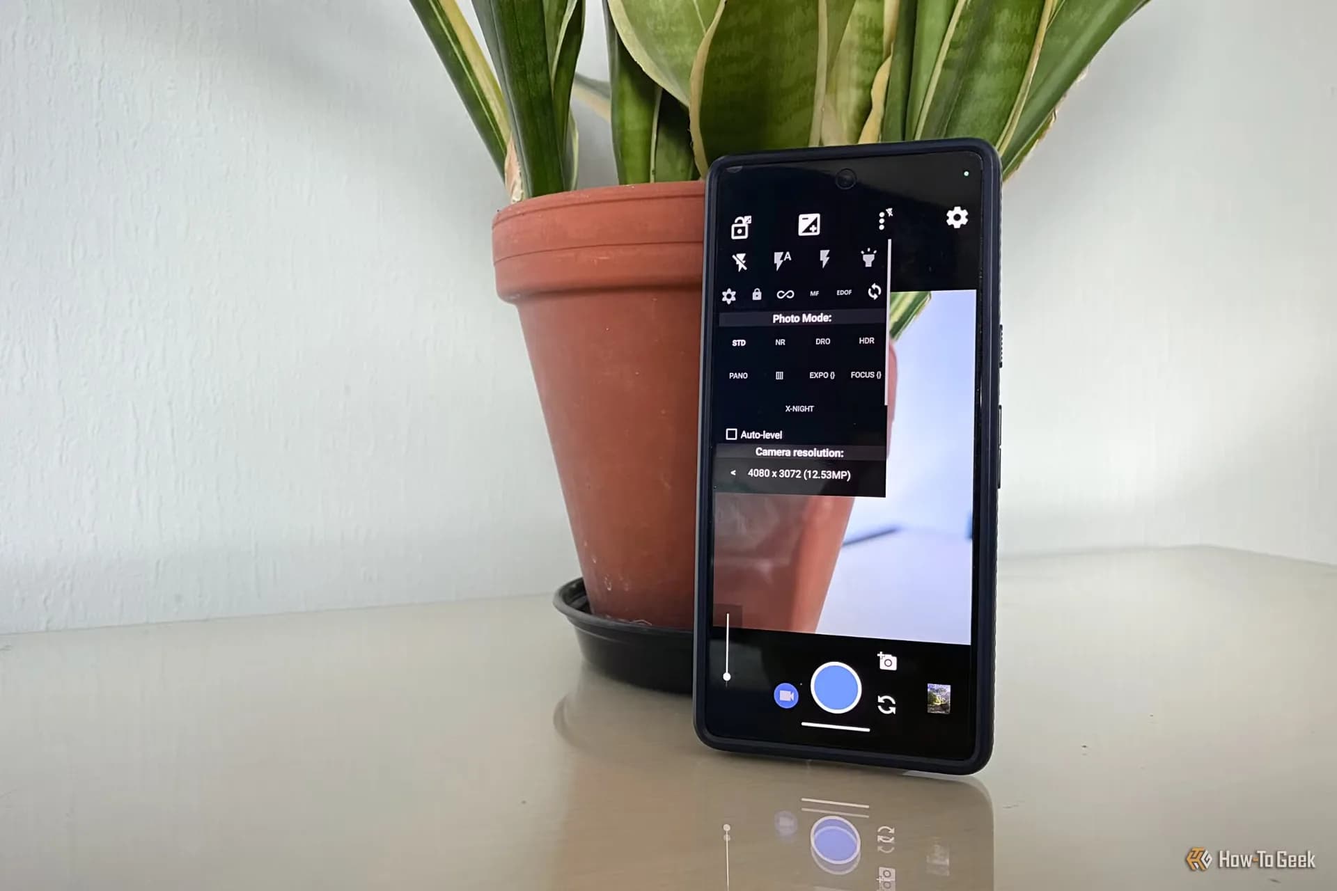 A smartphone displaying manual camera settings with shutter speed and exposure controls on screen.