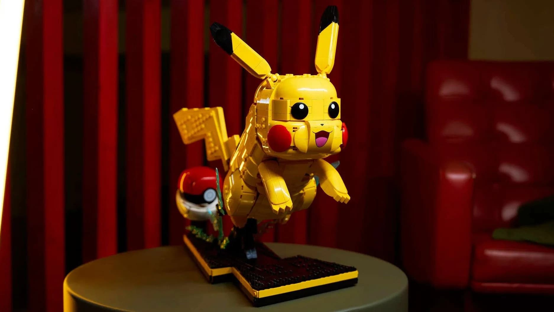 Lego Pikachu model posed leaping from an open Poke Ball display stand.