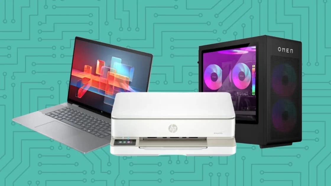 An HP laptop sitting open on an office table beside a monitor and mouse