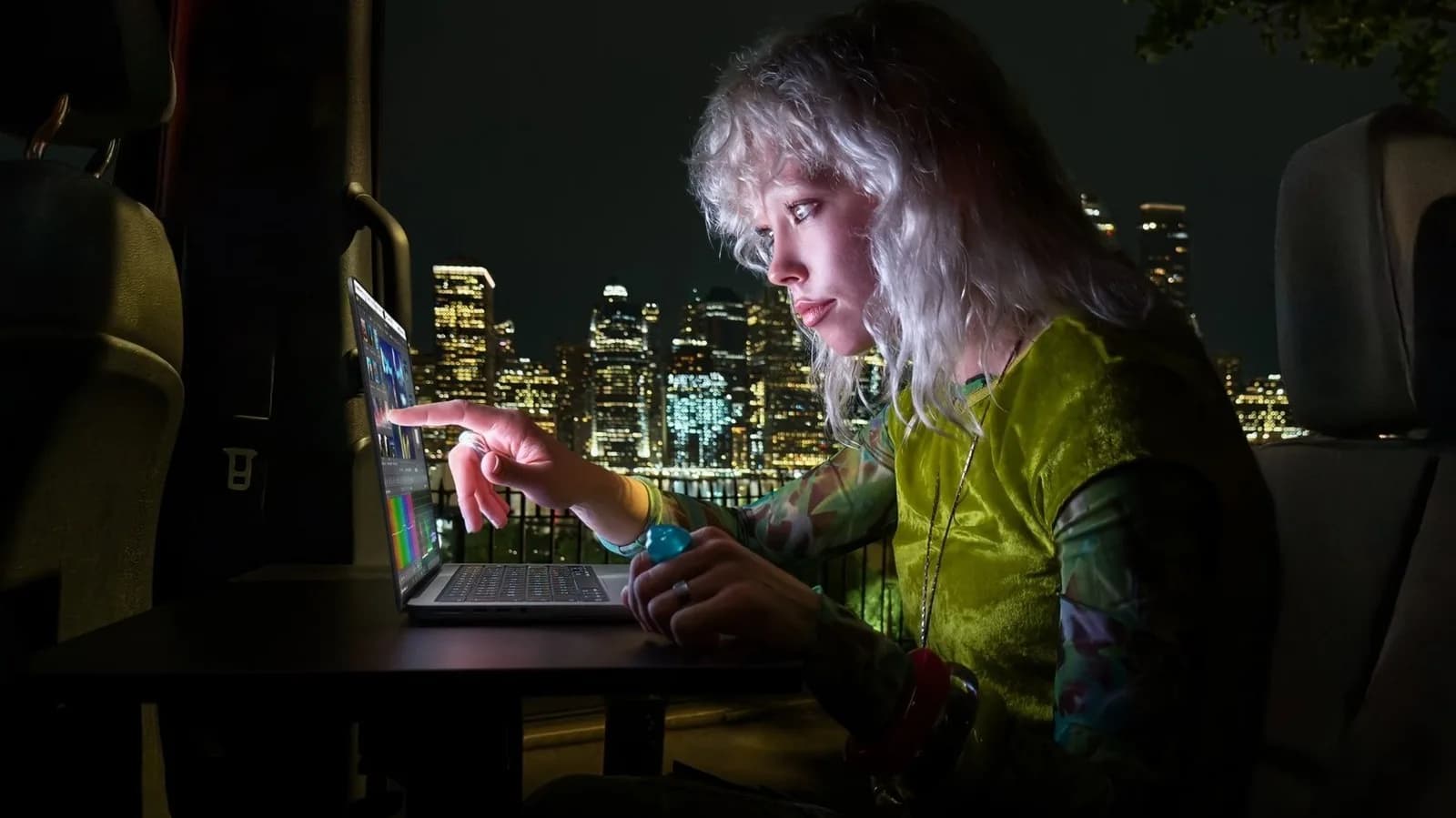 Apple MacBook Pro with OLED touchscreen display open on a desk