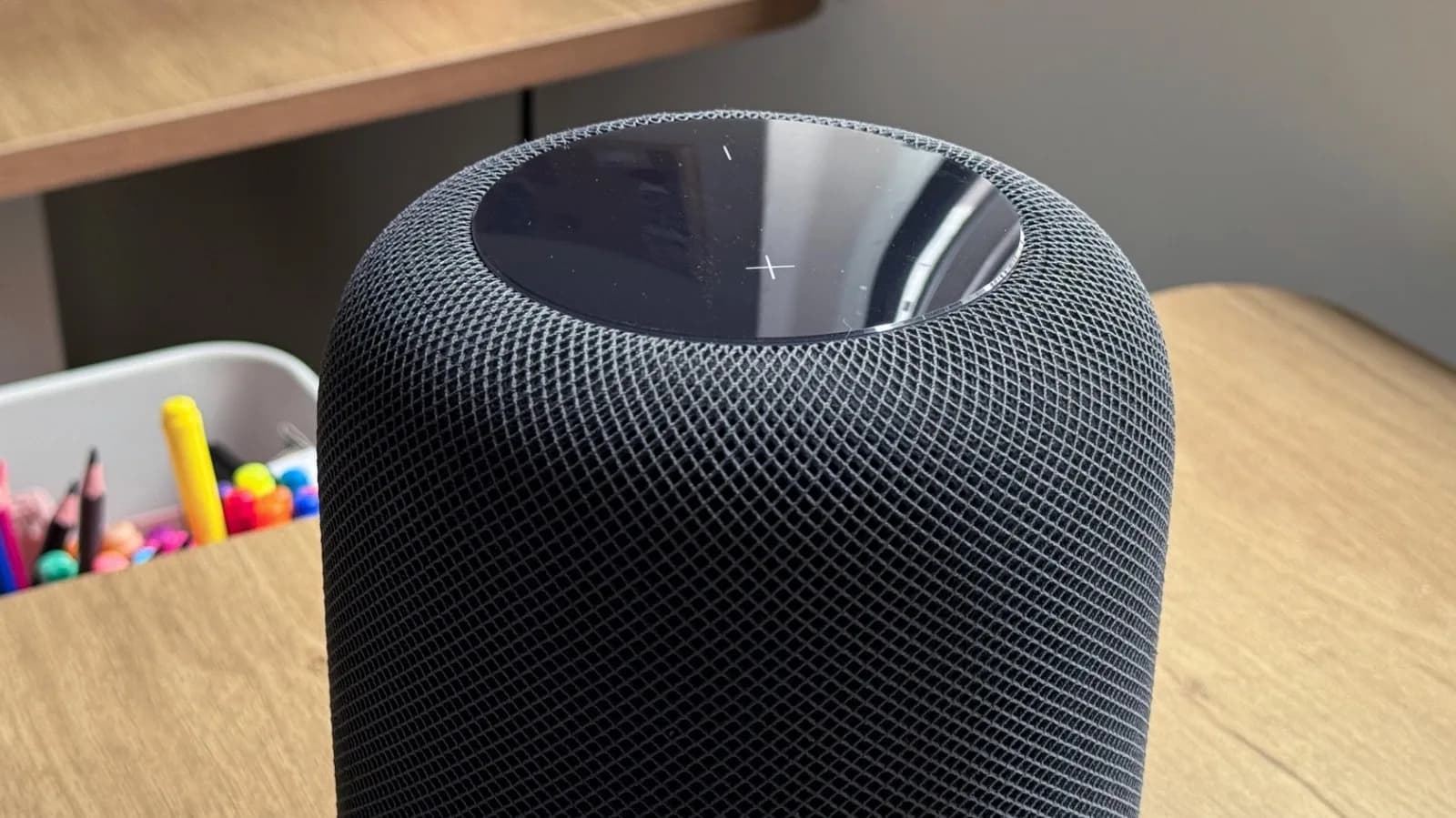 Apple HomePod mini smart speaker next to competing smart speakers on a table