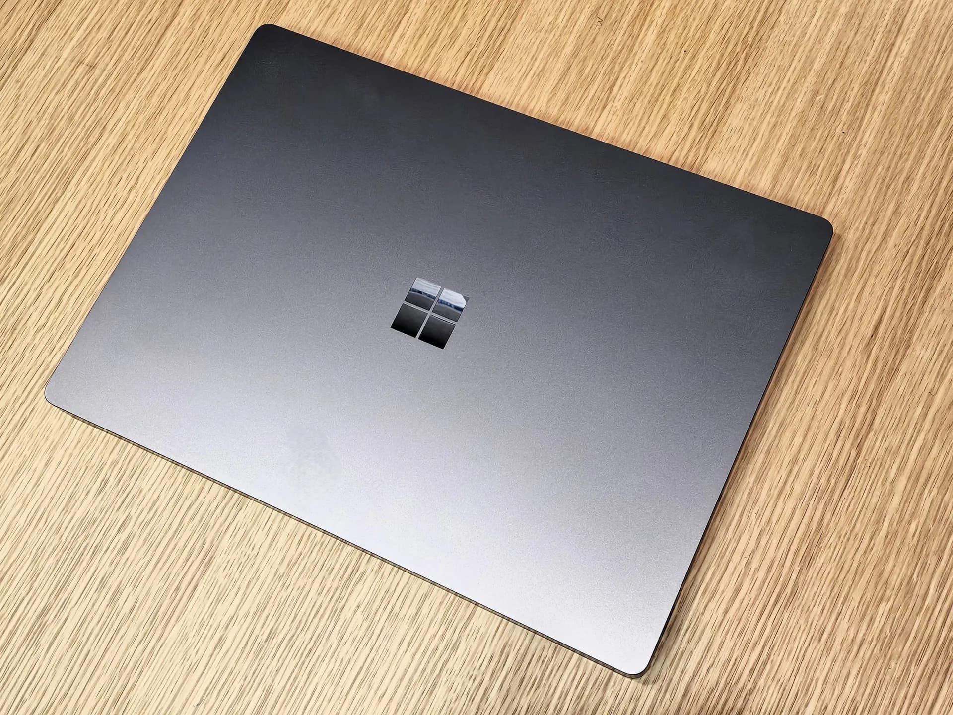 Microsoft Surface Laptop Ultra laptop shown open on a desk, matte black finish, keyboard lit