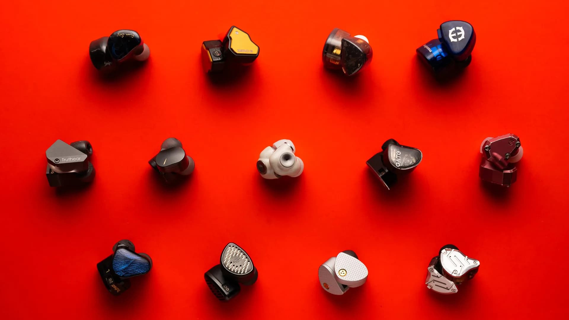 Pair of wired in-ear monitors resting beside a gaming controller on a dark desk