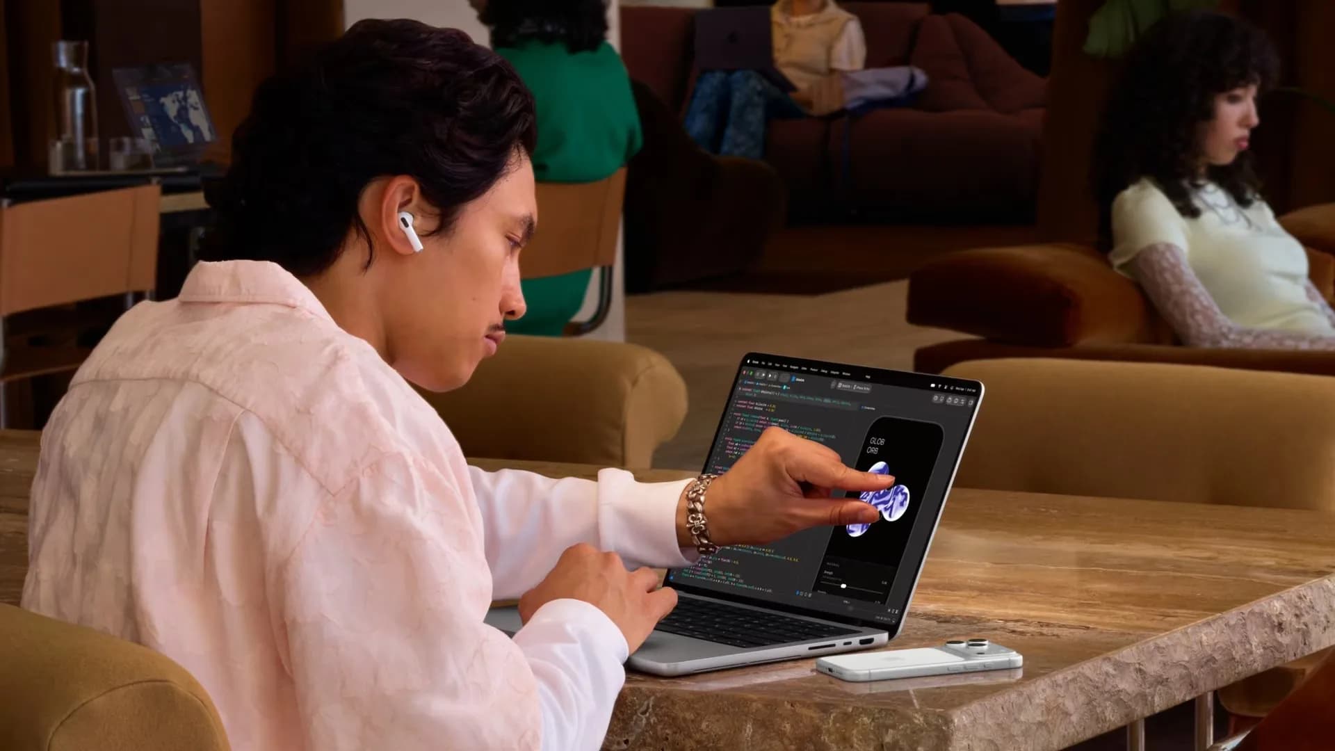 A person uses the touchscreen on Apple's MacBook Pro with PROLED XDR Display, shown in a press image.