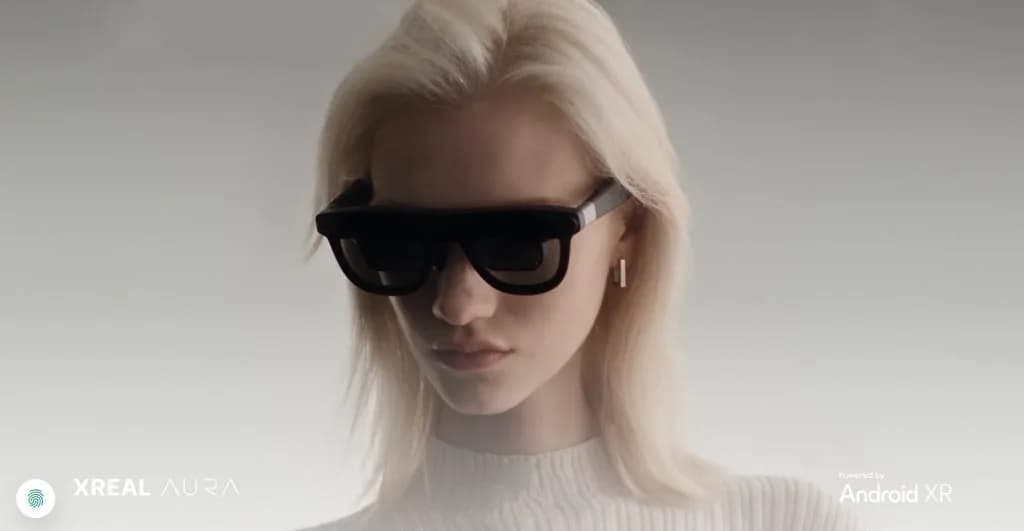 XREAL AURA XR glasses connected by cable to a compute puck, shown against a plain background
