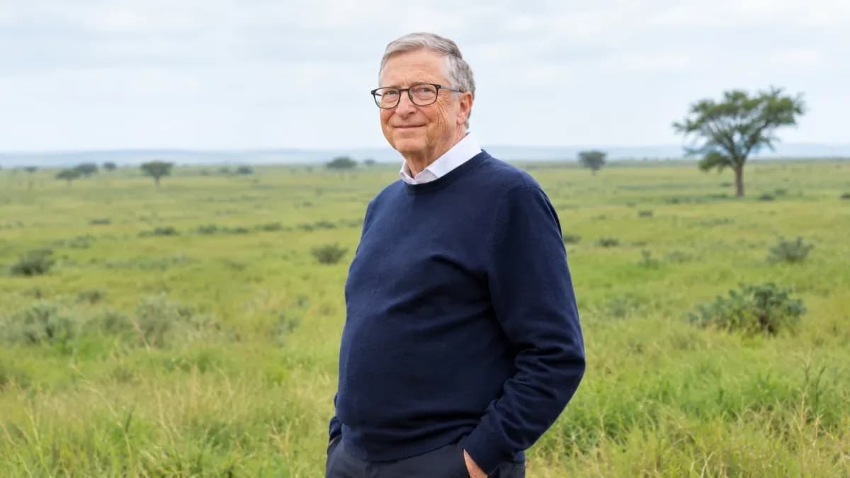 Bill Gates speaking during a podcast interview, with a smartphone showing a Claude AI chat interface in the foreground.
