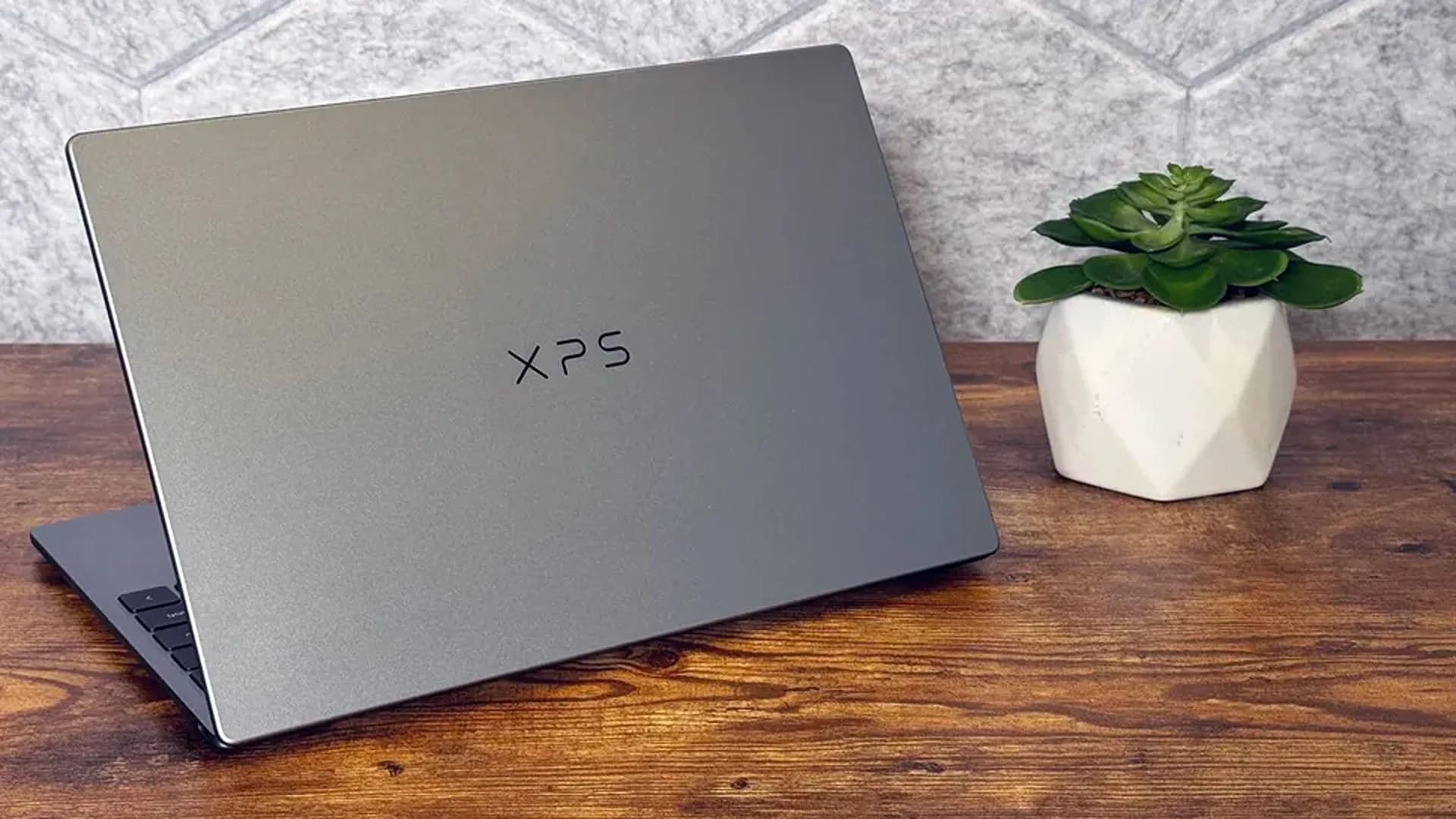 Dell XPS 13 laptop open on a table showing its touchscreen display and keyboard