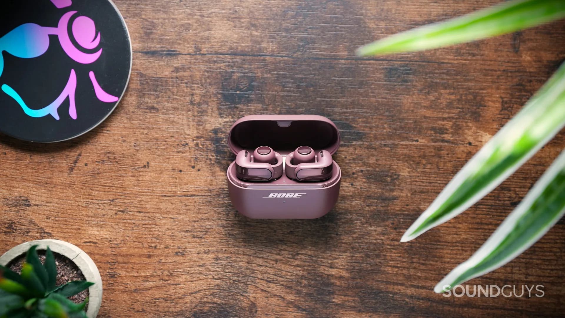 Bose Ultra Open Earbuds second generation resting in their upright charging case on a flat surface