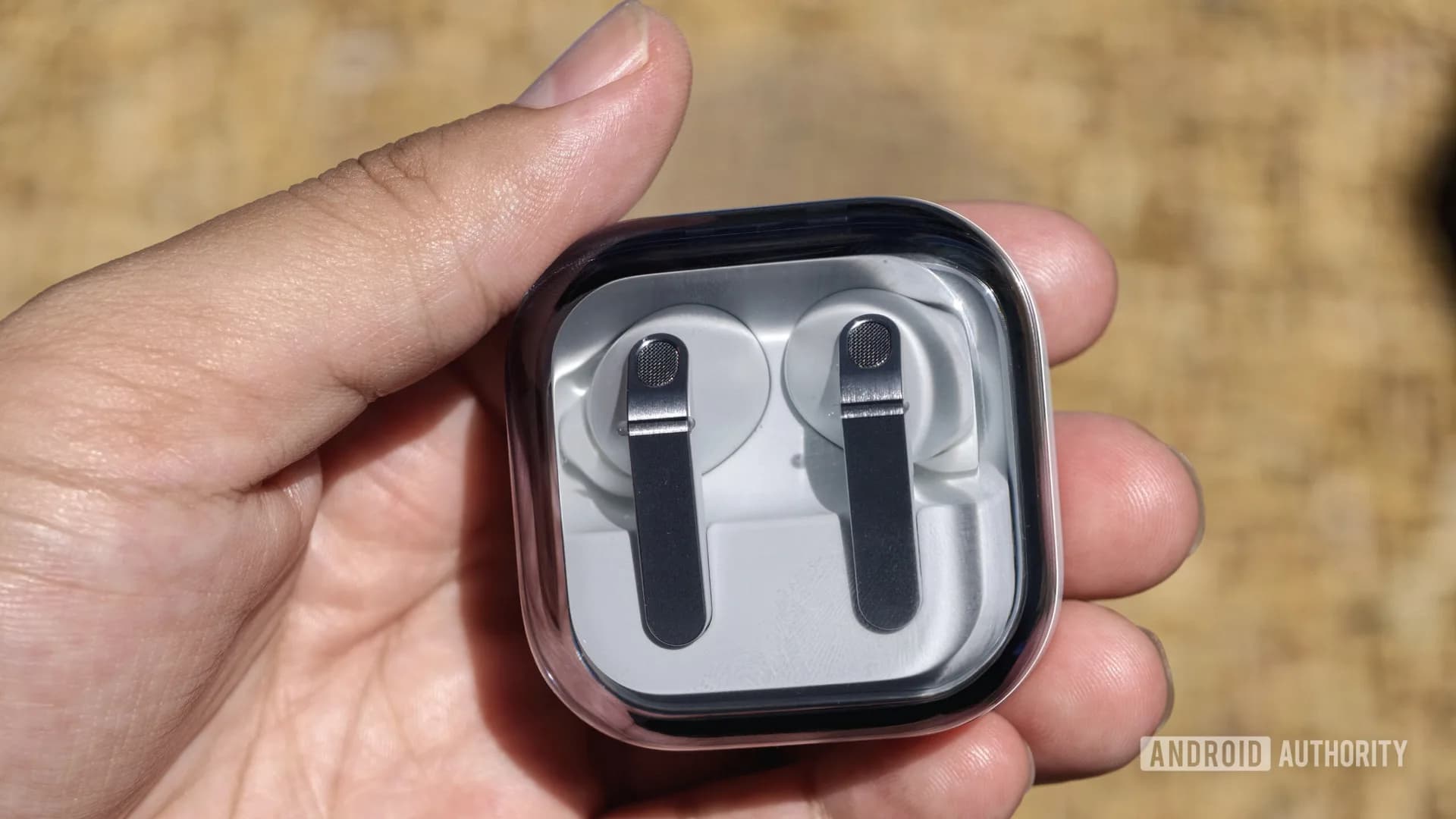 Pair of Samsung Galaxy Buds 4 Pro wireless earbuds resting next to their open charging case.