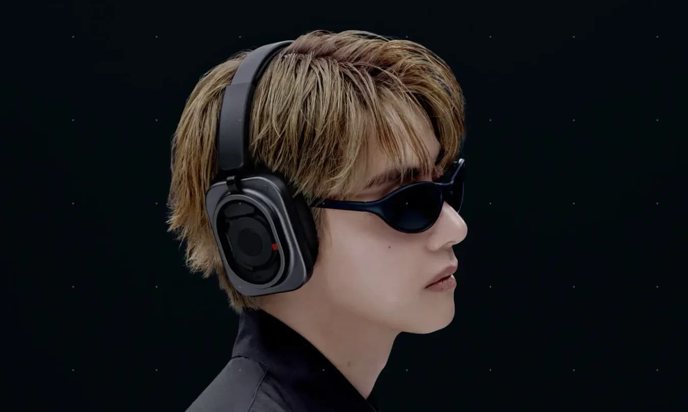 A pair of modern black smart glasses resting on a flat reflective surface