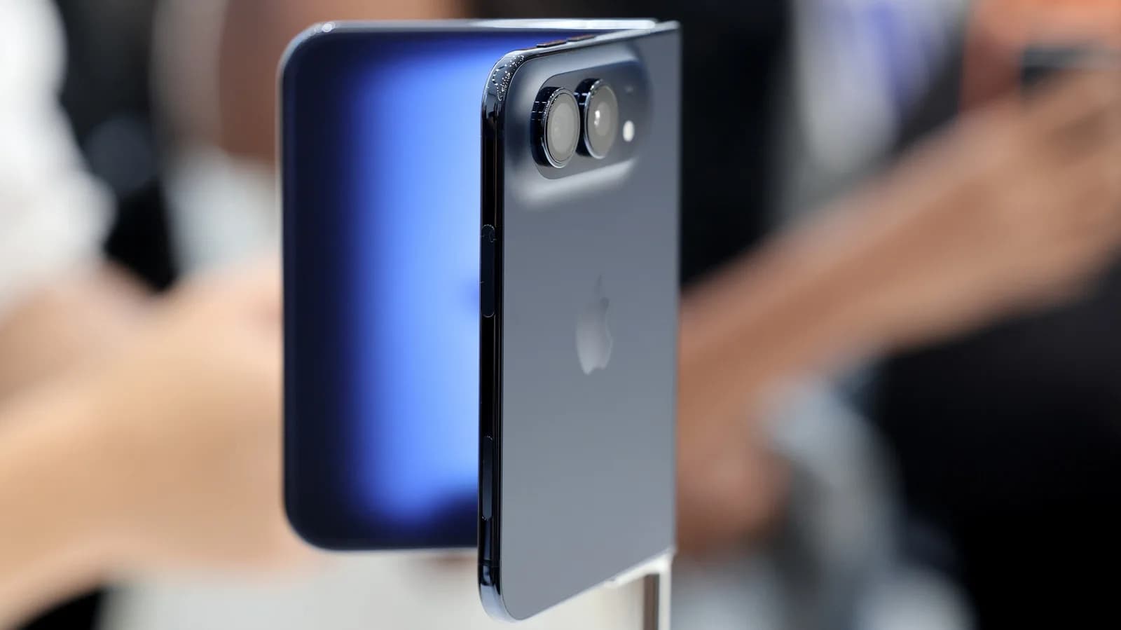 Foldable smartphone held open showing an interior flexible display next to its cover screen