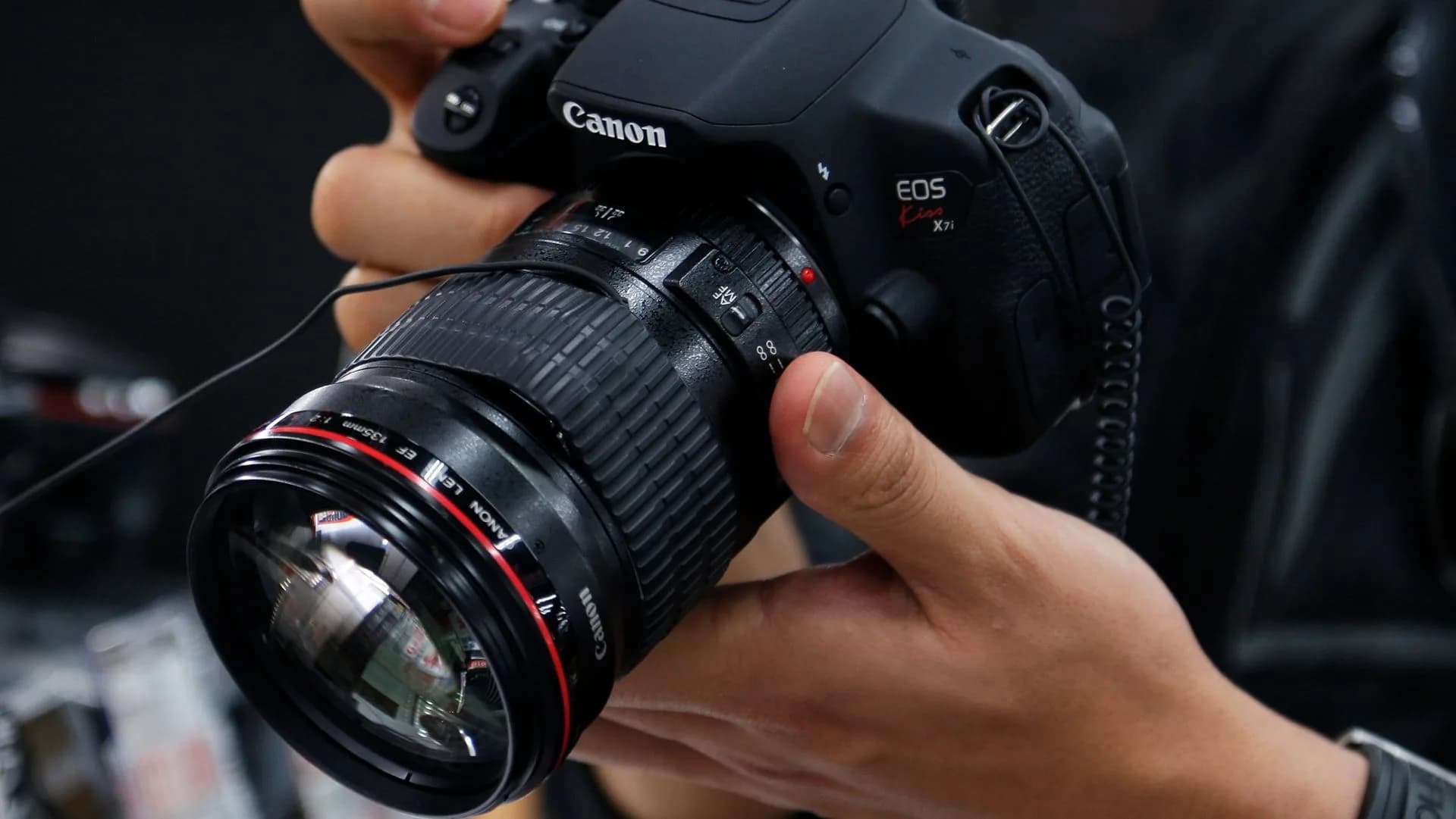 Canon camera lens resting on a flat surface with its front element visible