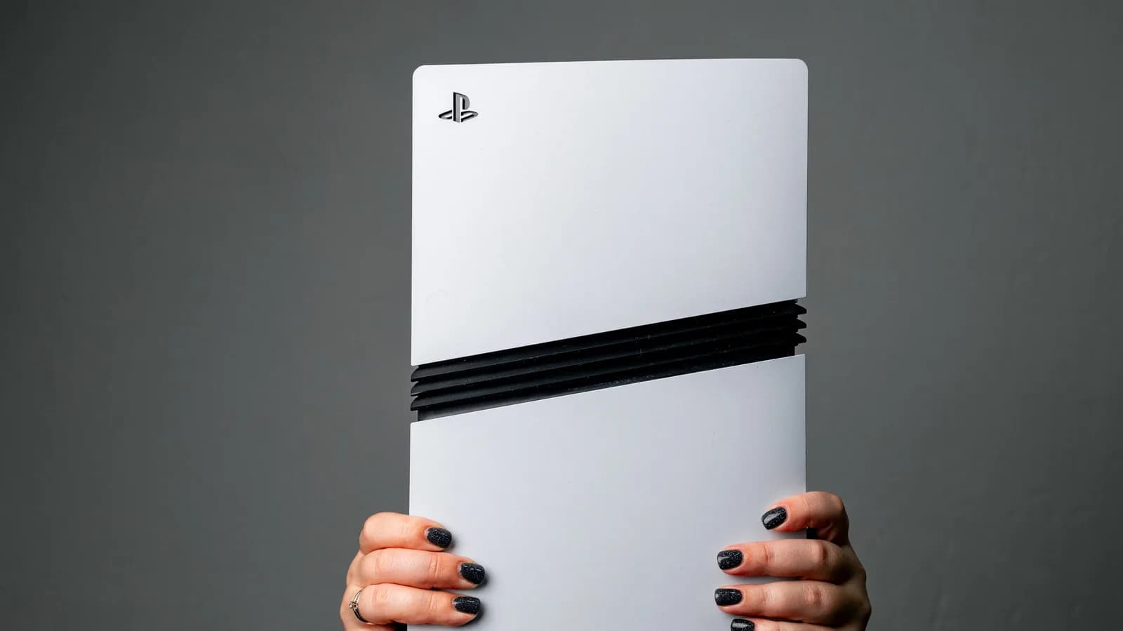Sony PlayStation 5 Pro console standing vertically next to a DualSense controller