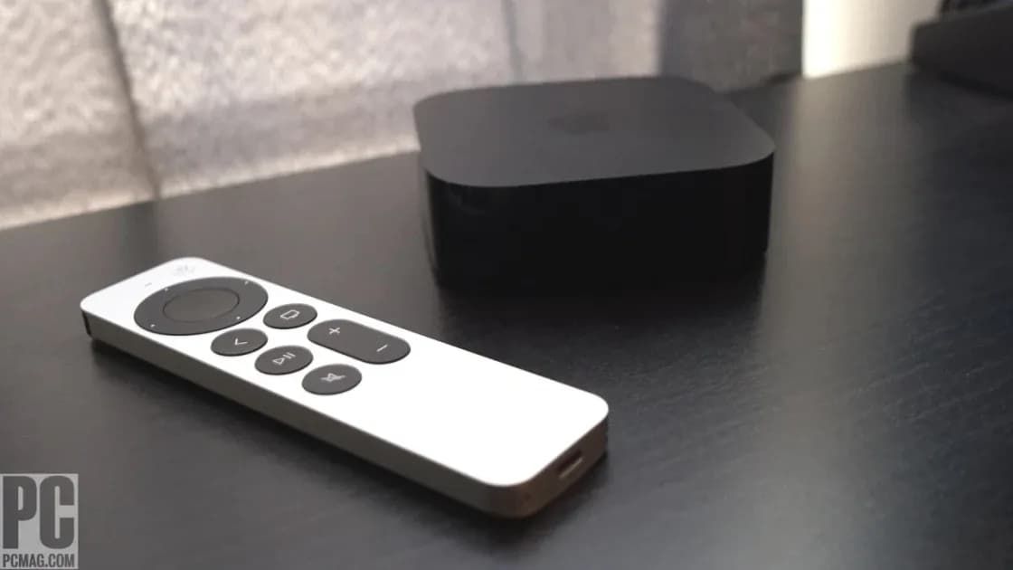 Apple TV 4K remote beside a black streaming box on a shelf
