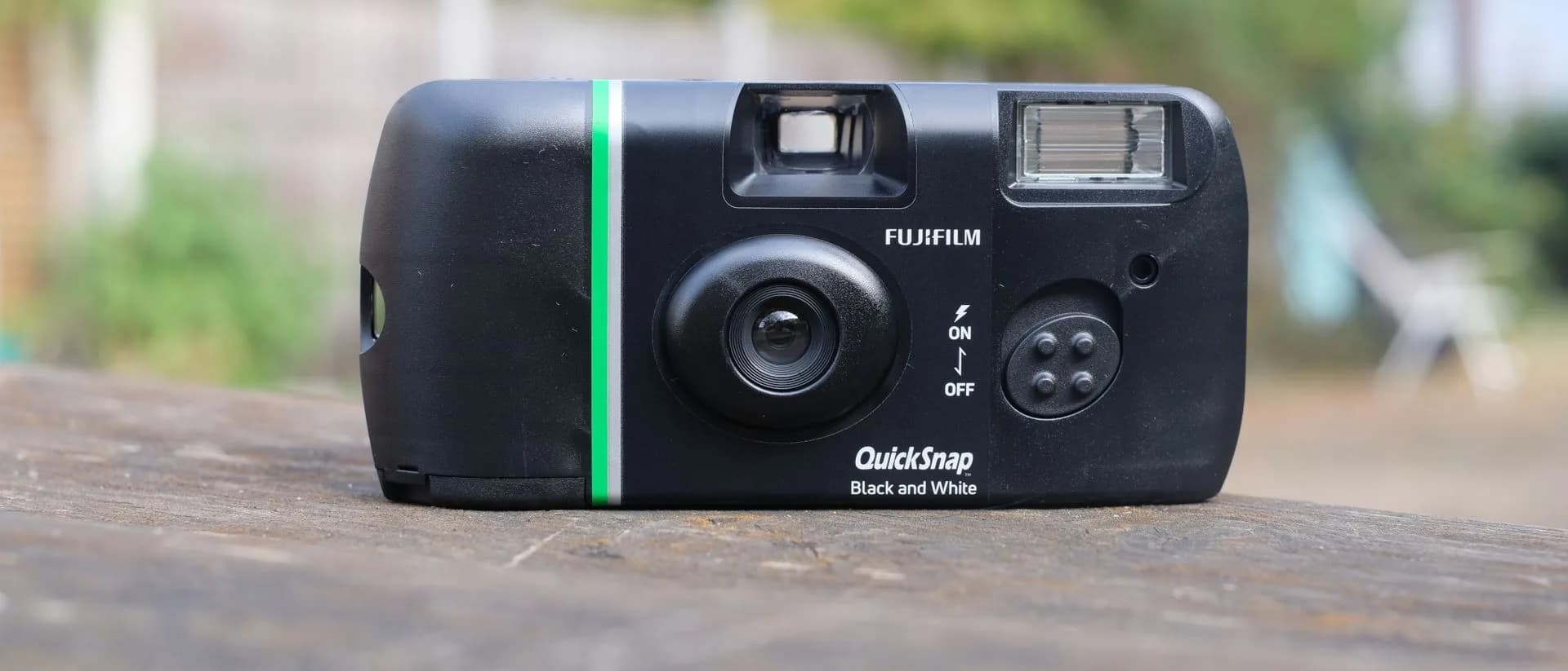 Fujifilm QuickSnap Black and White disposable 35mm film camera held against an outdoor background