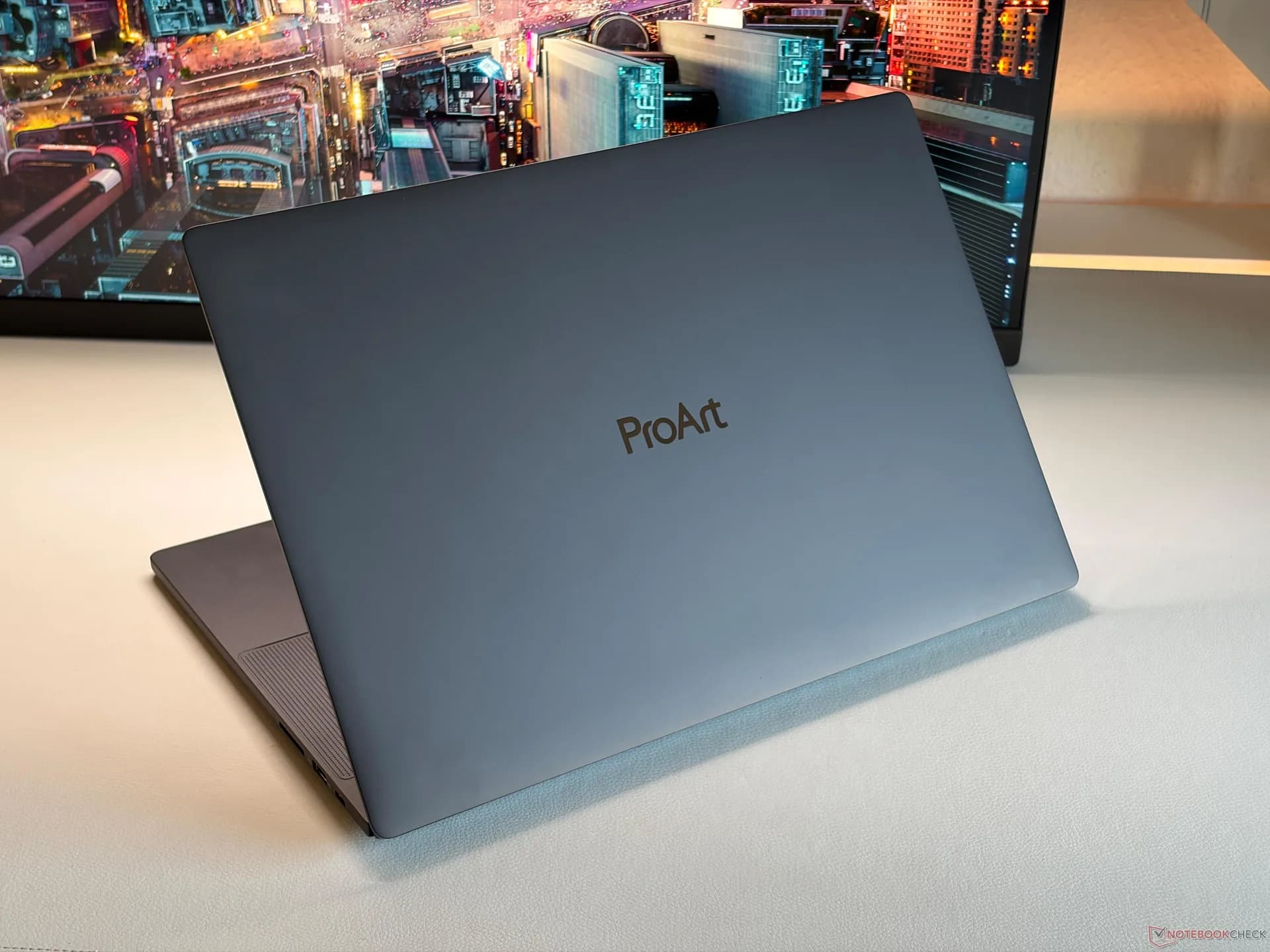 The Asus ProArt P16 laptop open on a studio desk displaying creative rendering software.