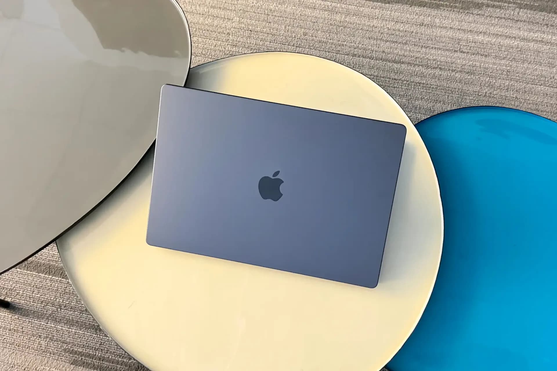 Apple MacBook Pro laptop resting open on a desk beside an external display.