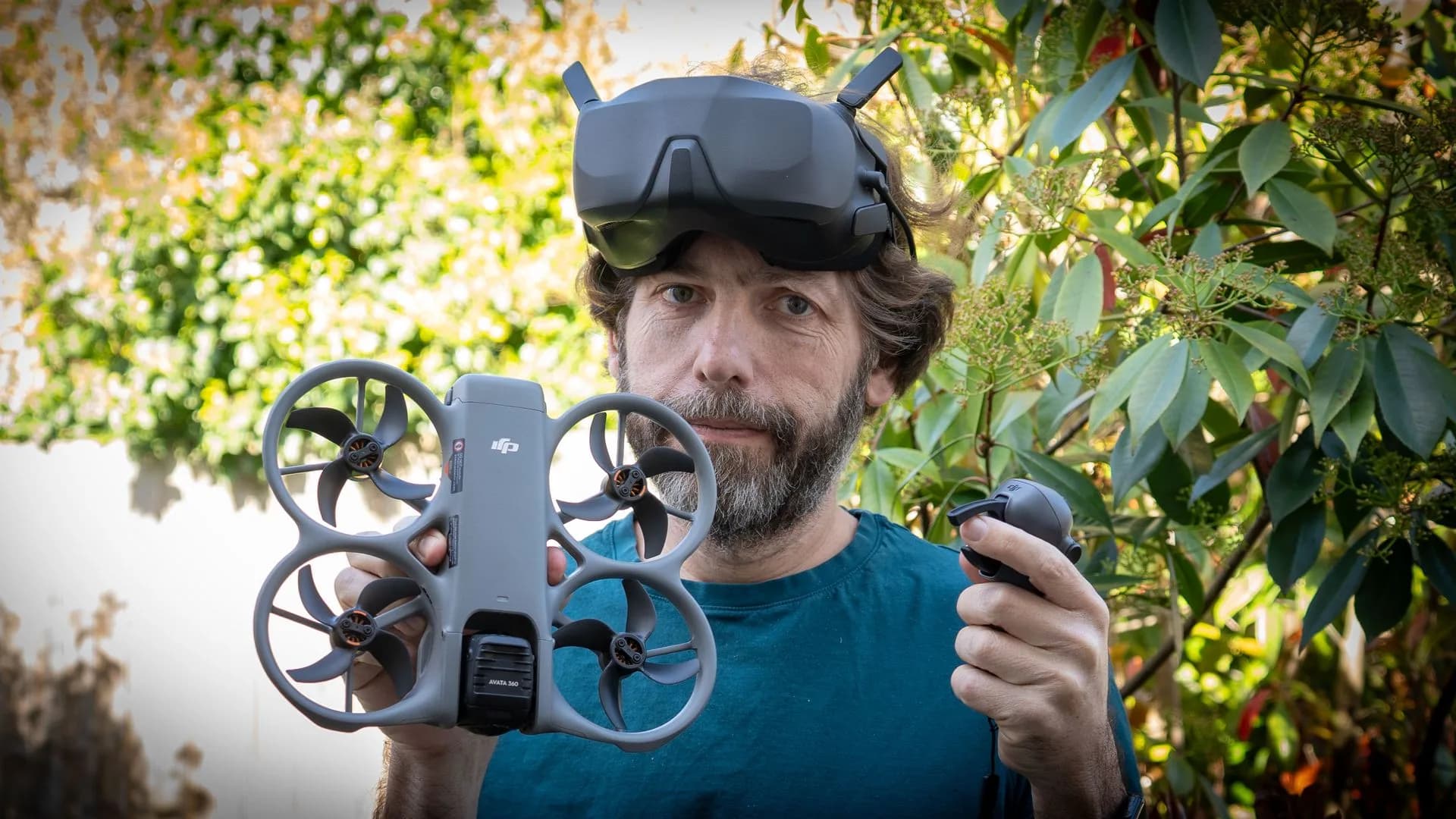DJI Neo drone folded in hand next to its remote controller