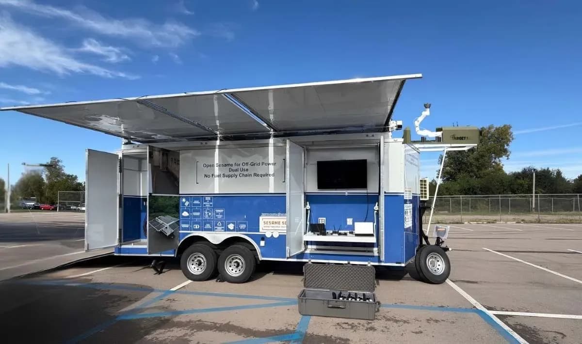 A rugged solar and hydrogen powered mobile hub deploying small drones with an automated robotic arm.