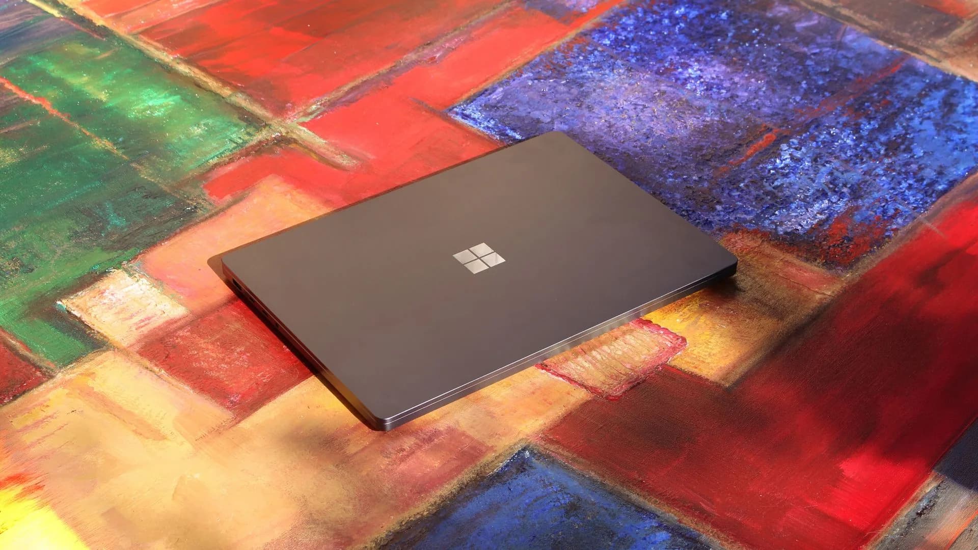 A row of premium creator laptops on a desk displaying workstation software