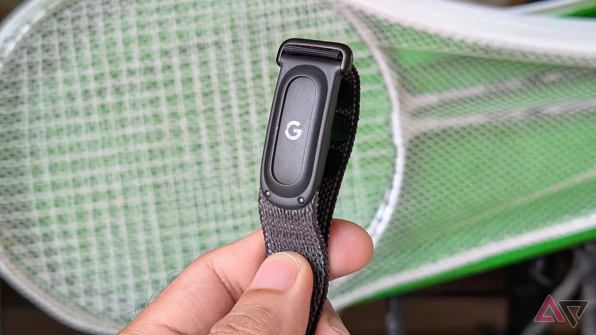 A Fitbit Air fitness tracker band shown on a wrist with the Google Health app sleep tracking screen nearby.