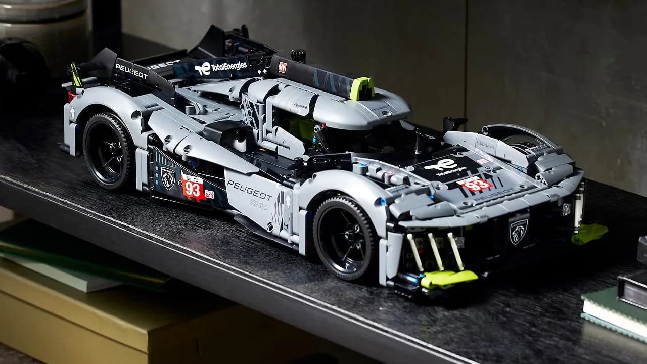 LEGO Technic Peugeot 9X8 Hybrid Hypercar (set 42156) assembled on a white surface, front three-quarter view, green glow elements visible