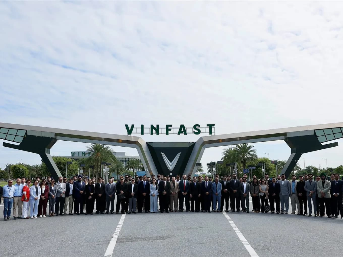 VinFast logo beside a render of an electric motorcycle in front of a modern Indian showroom facade