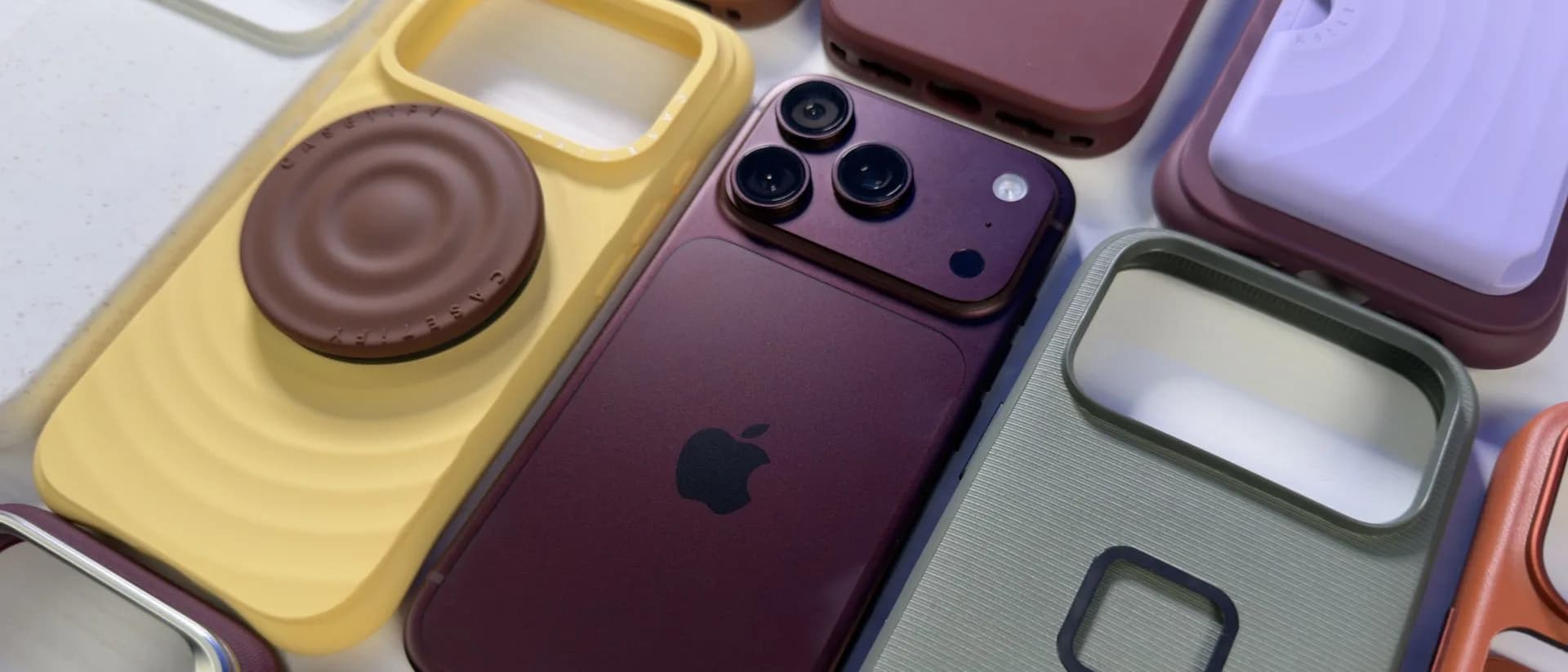 Several iPhone 18 Pro cases from different brands laid out side by side, including silicone, leather and clear designs.