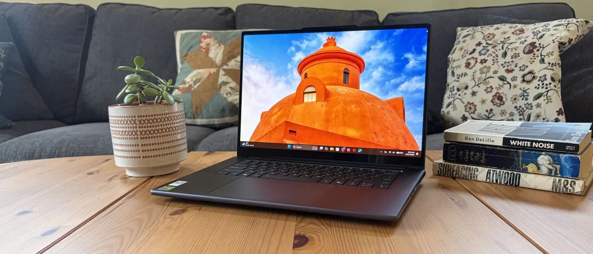Lenovo Pro 9n laptop open on a desk showing its OLED display and keyboard