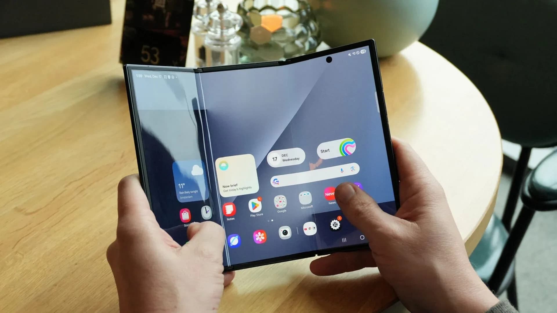 A side-by-side conceptual comparison of foldable phone hinges on a factory workbench.