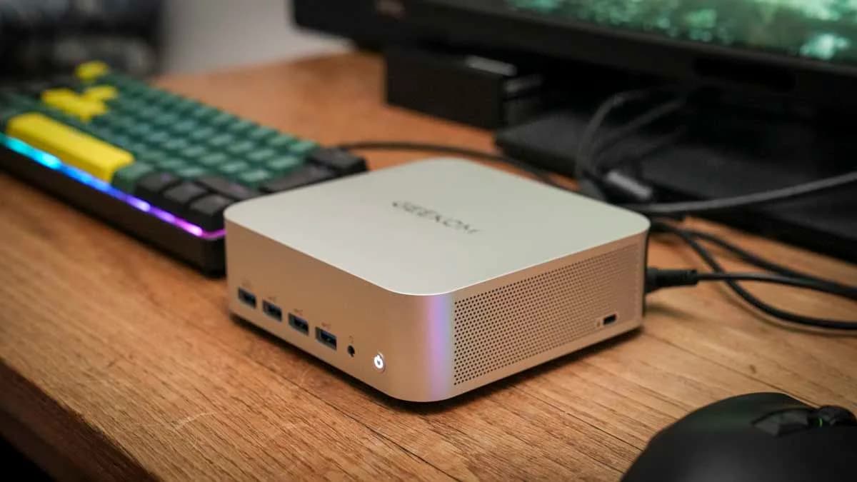 Geekom A8 Max mini PC on a desk beside a monitor and keyboard