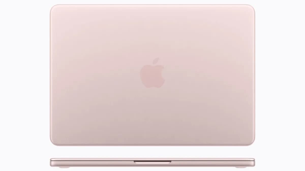 Apple MacBook Neo on a wooden desk, front-facing, showing thin bezels and Apple logo