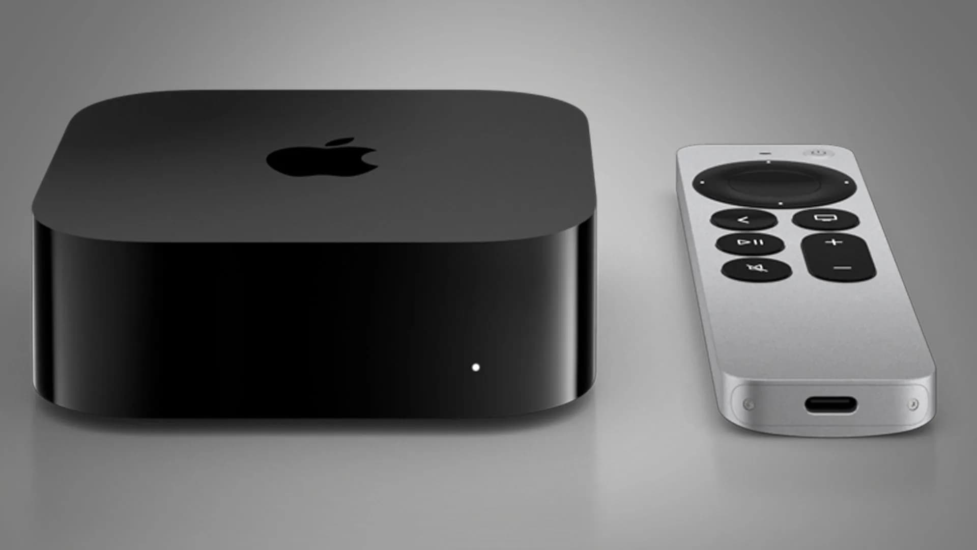 Apple TV 4K remote next to a home theater receiver showing Dolby Atmos active