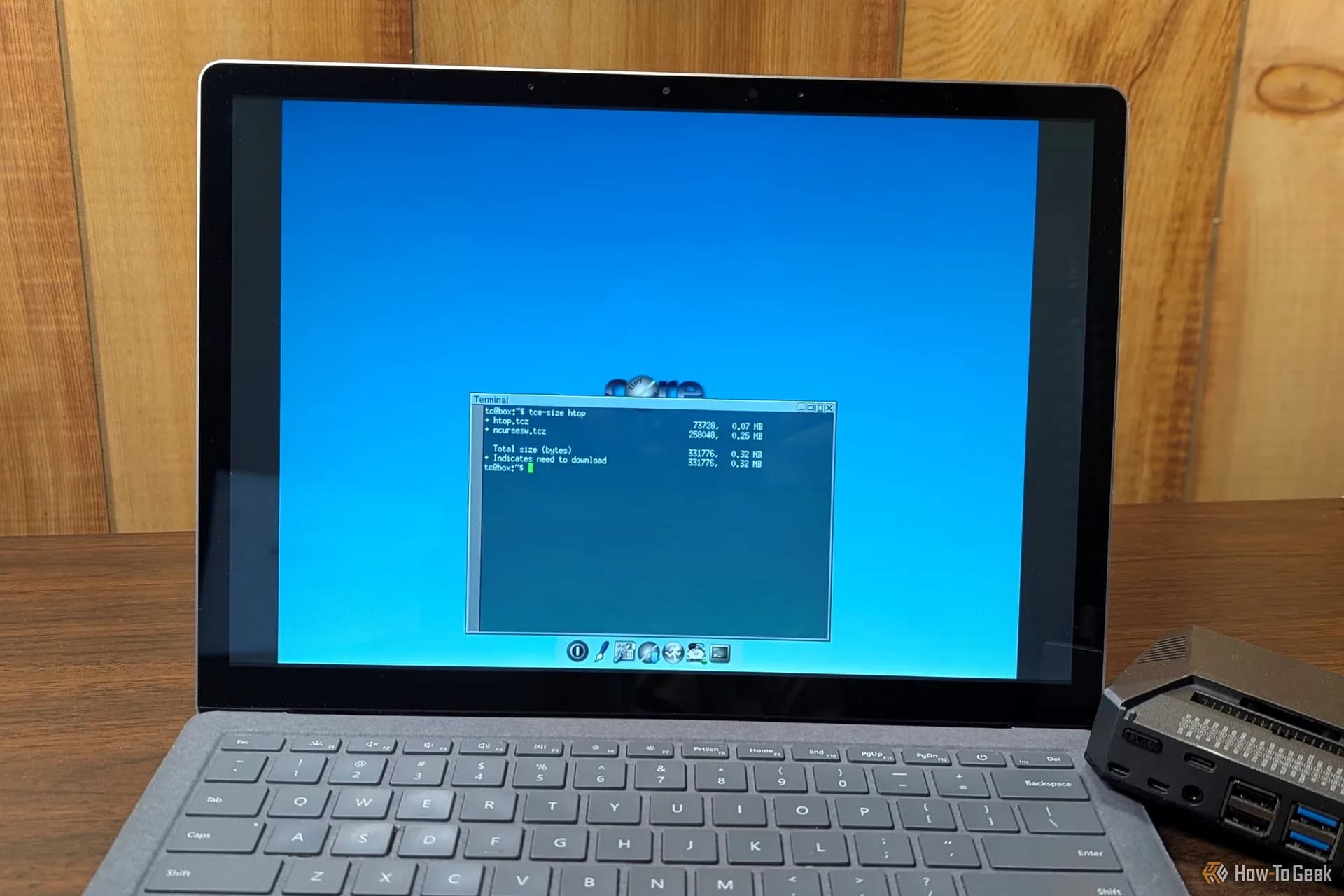 An older open laptop running a lightweight Linux desktop terminal interface
