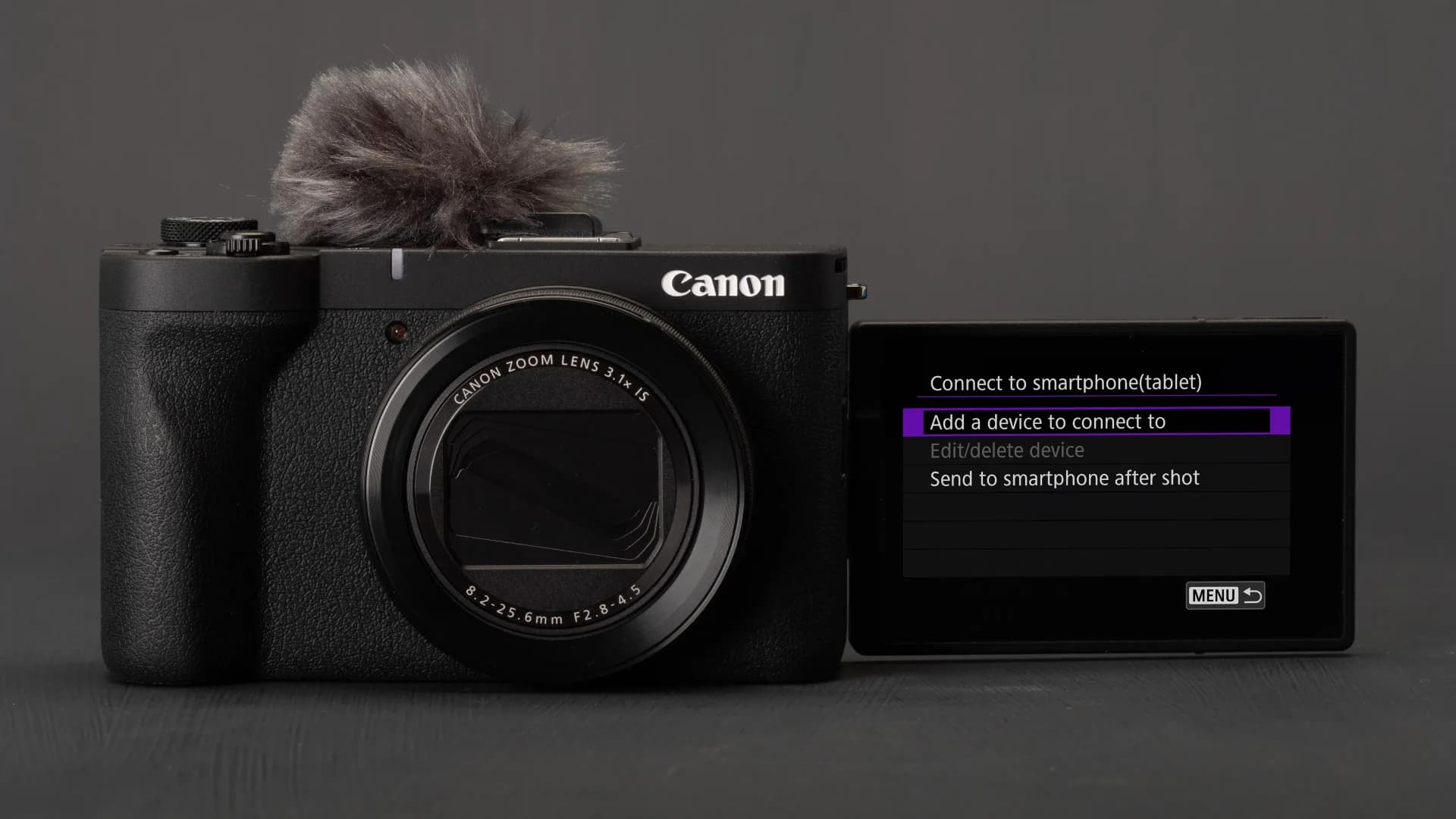 Canon camera sitting next to a smartphone displaying live view remote shooting controls.