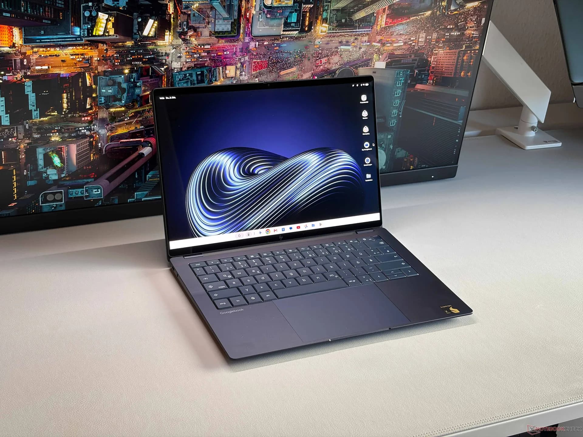 HP Googlebook 14c laptop in dark blue resting on a desk with its display turned on